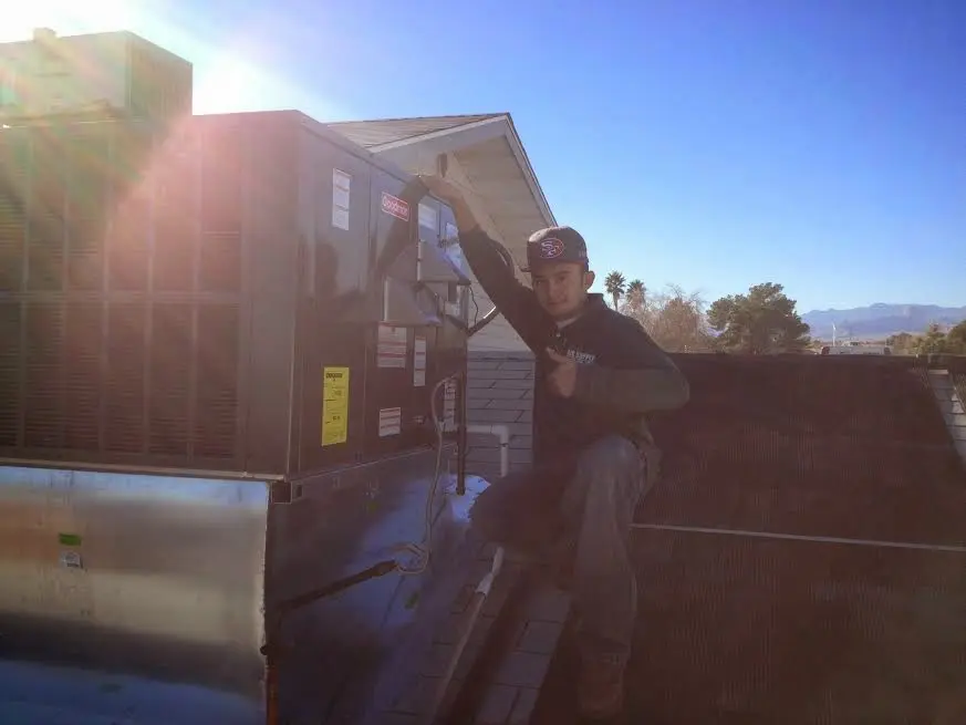 HVAC technician performing HVAC Inspection on a rooftop unit in Ensley
